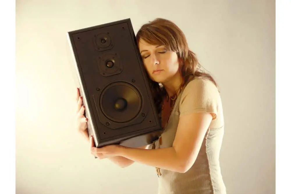 Are Bigger Speakers Better? Woman hugging speaker.